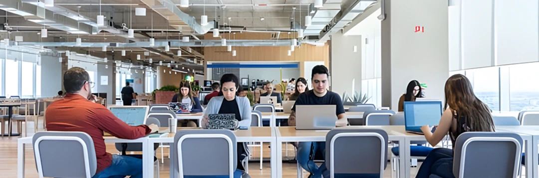 Dizüstü bilgisayarlarla çalışan ekiplerle modern, açık ofis alanı