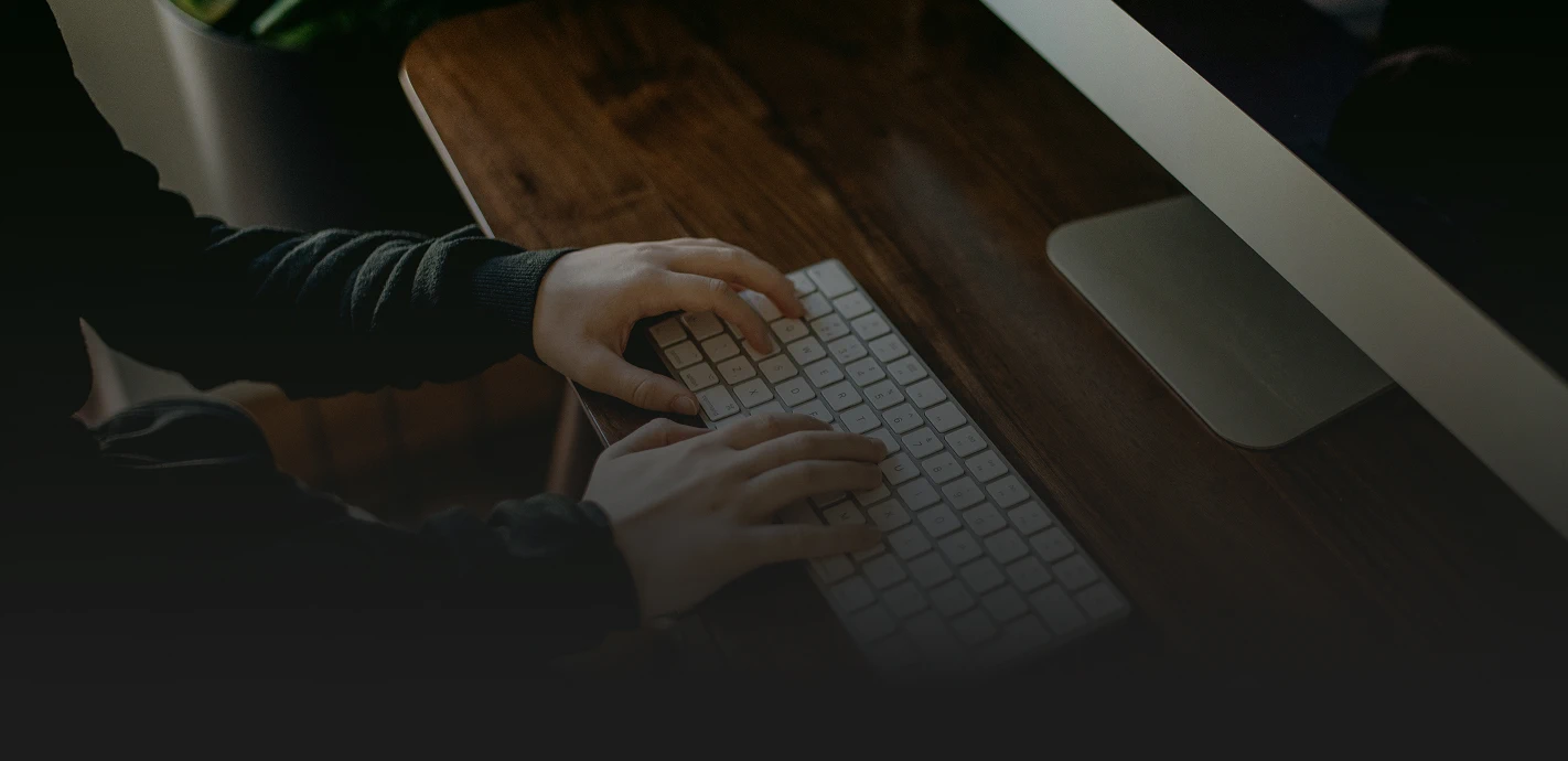 Person typing on computer keyboard, close-up view