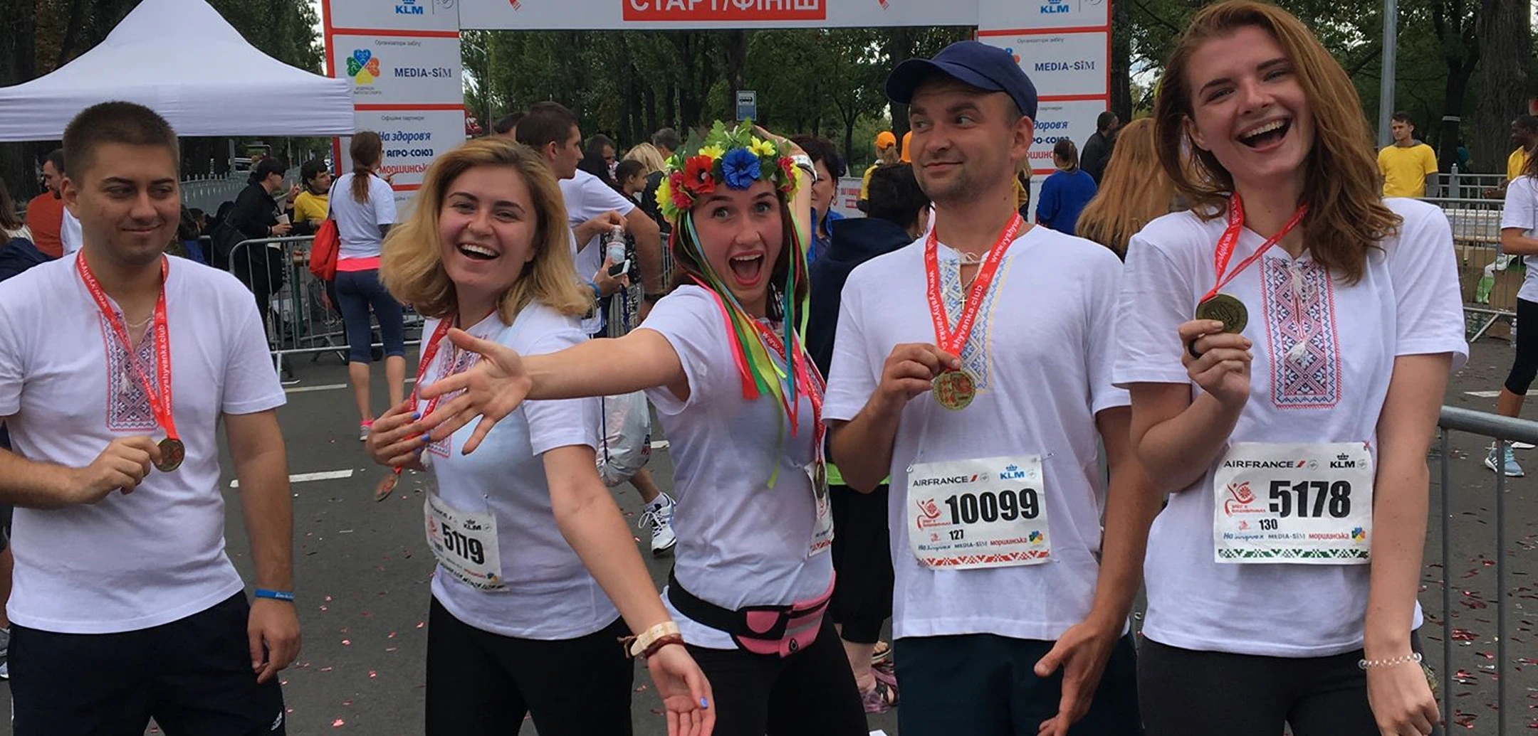 Five Ukrainian Cognitime employees celebrate the finish of the marathon in traditional embroidered shirts