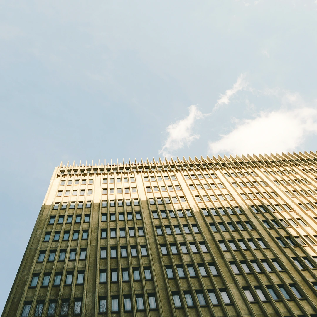 The facade of a tall, rectangular building is shown from a low angle