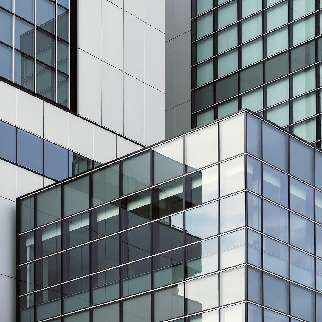 Close-up of a modern building exterior with geometric glass windows and grey metal panels