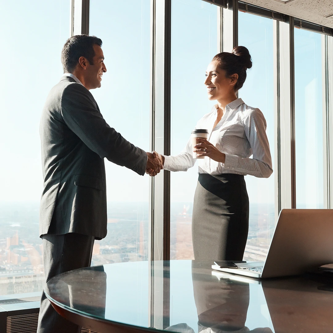 Business meeting in a modern office with two professionals shaking hands