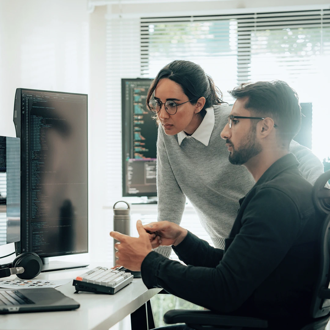 Two retail customer service employees with glasses communicating at work