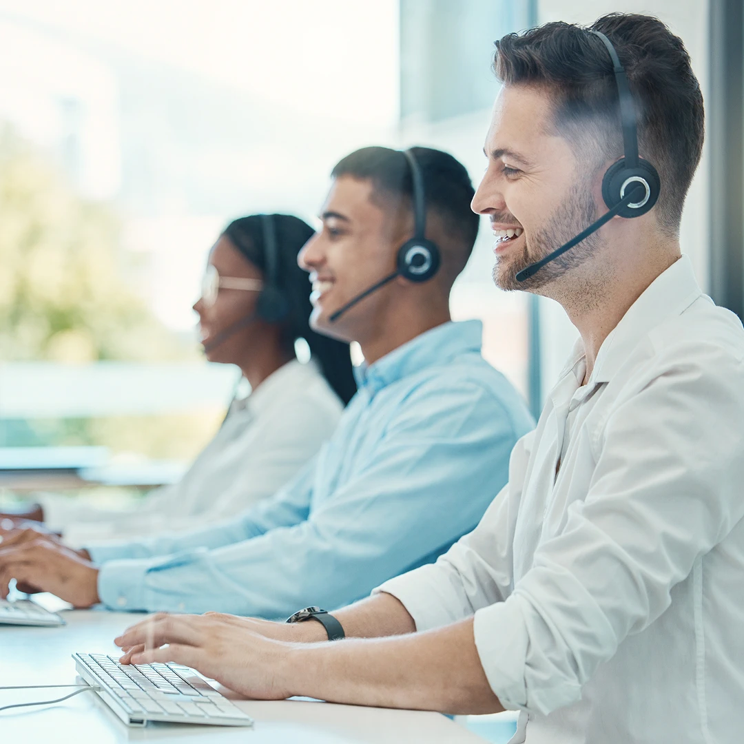 Friendly and professional customer support team wearing shirts and working at their workstations