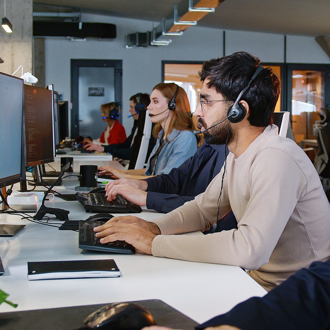 A team of customer service representatives wearing headsets, working on computers in a Chicago call center