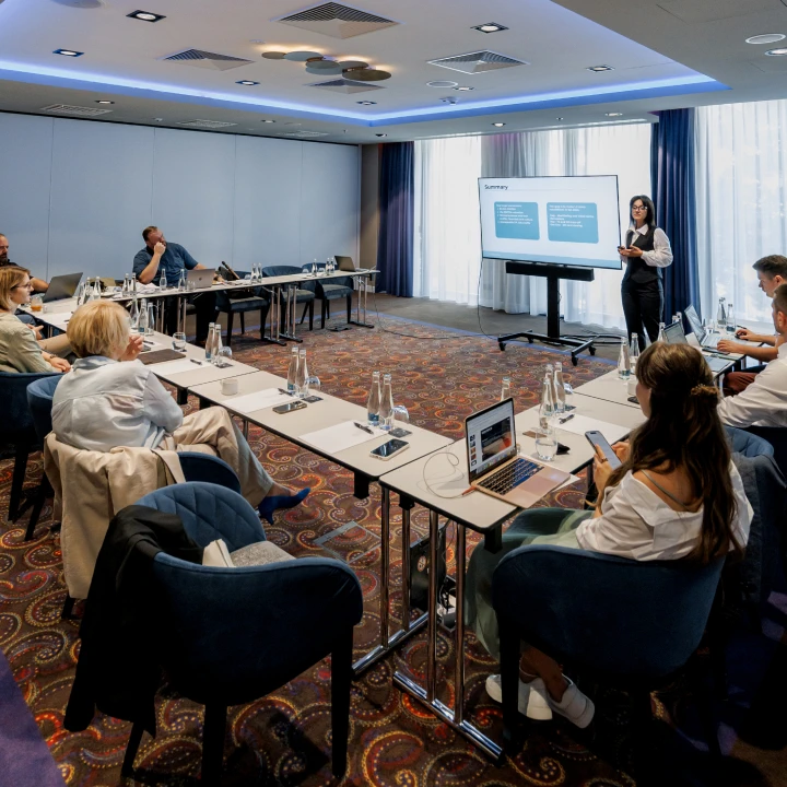 some conference going on with a bunch of pople sitting in front of their laptops