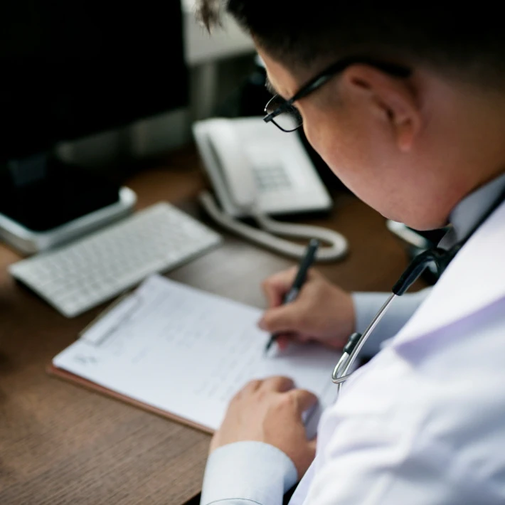 a doctor writing something down on a paper