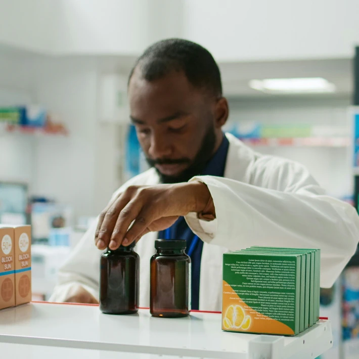 a pharma worker standing next to pharmaceutical products